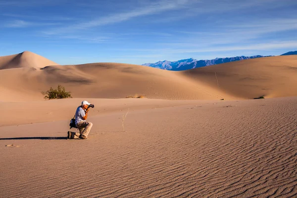 带着照片袋的旅游摄影师热情洋溢地拍照 死亡谷沙坑里的沙漠清晨 摄影旅游的概念 — 图库照片