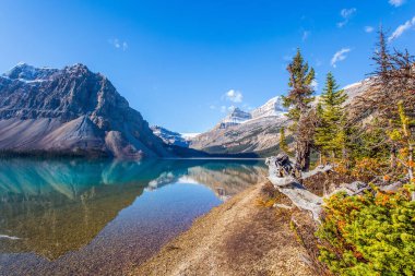 Rocky Dağları, Kanada. Temiz gök mavisi suyu ile buzul gölü yayı. Dağlar gölün yumuşak suyuna yansıyor. Güneşli bir sonbahar günü. 