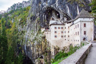 Parktaki eski ortaçağ kalesi. Slovenya 'da sihirli yerler. Ülkedeki en ünlü ve en çok ziyaret edilen yer turistler. Limestone Platosu 'ndaki Postojna Mağarası.