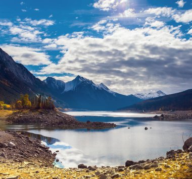 Kanada, Alberta, Jasper Park. Lake Medicine 'de. Harika bir sonbahar günü. Güneş karla kaplı dağları aydınlatır. Aktif, ekolojik ve fotoğraf turizmi kavramı