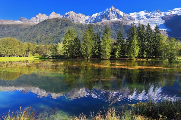 Im Wasser spiegeln sich schneebedeckte Berge — Stockfoto