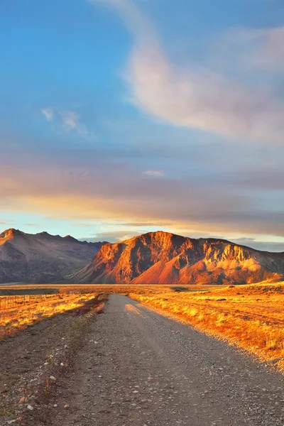 The sunset sun shines mountains with red light — Stock Photo, Image