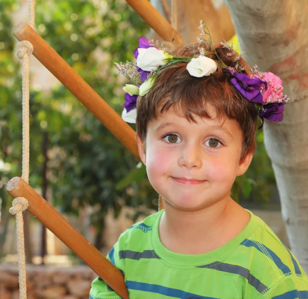 De jongen draagt een krans van bloemen — Stockfoto