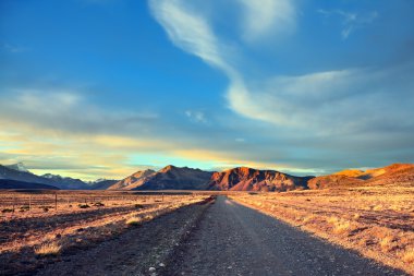 gravel road between boundless Pampas