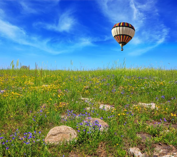 Flying big colorful balloon in field — Stock Photo, Image