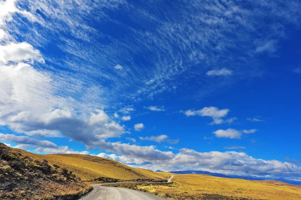 Gravel road crosses the valley — Stock fotografie