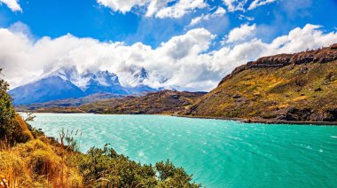 Los Cuernos 'un muhteşem kar kaplı siyah uçurumları. Lago Pehoe. Torres del Paine Parkı. Chiles Patagonia. Eriyen buzulların suyunun gök mavisi var..