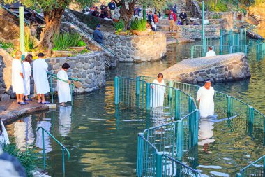  YARDENIT, ISRAEL - 21 HAZİRAN 2012: inananlar için sembolik vaftiz töreni. Beyaz vaftizli bir grup inanan Ürdün Nehri 'nin sularına girer. Ürdün Nehri 