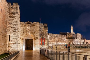 Kudüs 'ün tarihi duvarlarındaki taş kapı. Kutsal Şehir 'de yağmurlu bir kış akşamı. Islak taş duvarlar ve kaldırımlar fener ışığında parlıyor. Davut 'un Kulesi. İsrail