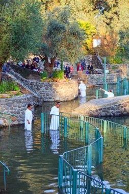 YARDENIT, ISRAEL - 21 HAZİRAN 2012: Ortodoks ve Katoliklerin vaftiz töreni. Beyaz vaftizli bir grup inanan Ürdün Nehri 'nin sularına girer.