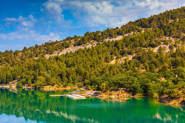 Vattnet i floden reflekterar skogsklädda strand — Stockfoto