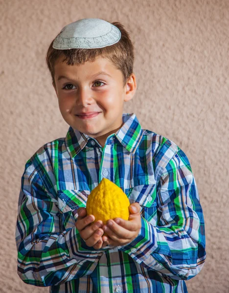 Boy v čapce drží citrusových — Stock fotografie