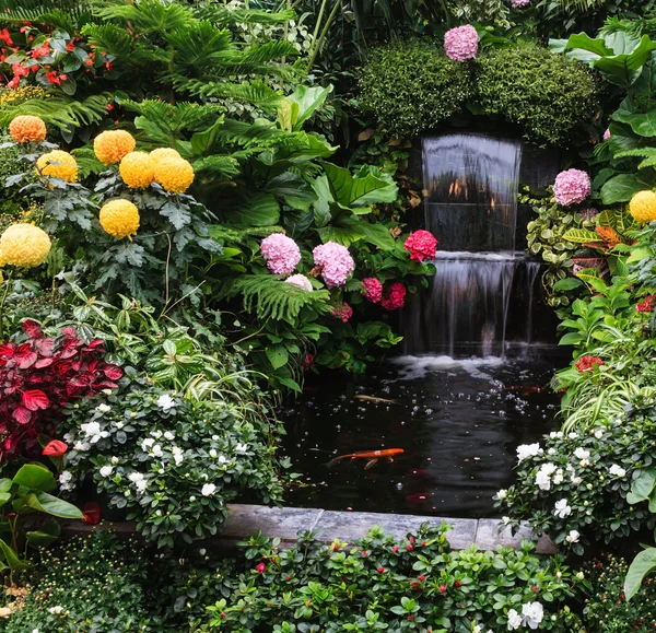 Fuente rodeada de flores . — Foto de Stock