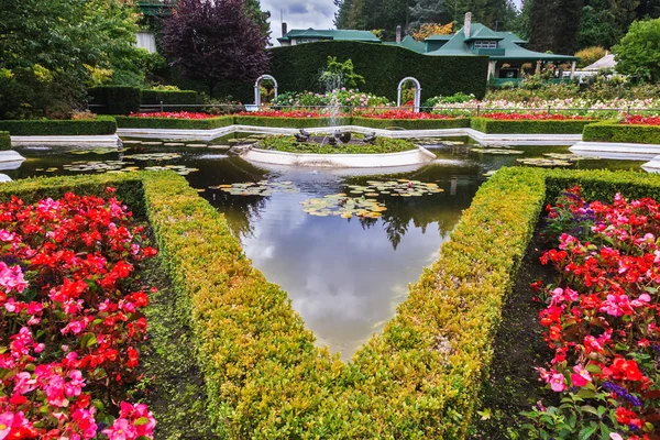 Fountain among flower beds — Stock Photo, Image