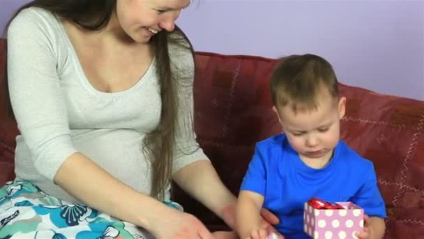 Happy pregnant woman presents gift to his little son. — Stock Video