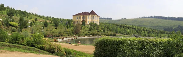 Cottage e lago de primavera. Arboreto de Canil Blooming Valley. — Fotografia de Stock