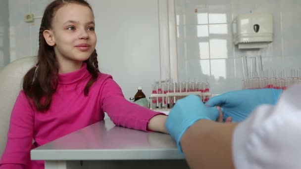 Enfermera toma sangre de un dedo del niño en el laboratorio médico . — Vídeo de stock