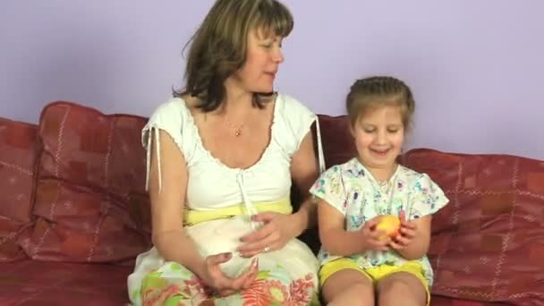 Fröhliche Frau mit kleiner Enkelin isst köstliche Äpfel. — Stockvideo