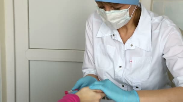 Verpleegkundige neemt bloed van een vinger van kind in medische laboratorium. — Stockvideo