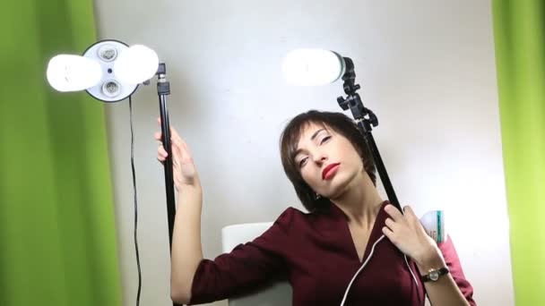 Hermoso modelo emocional posando en la cámara con equipo de luz . — Vídeo de stock