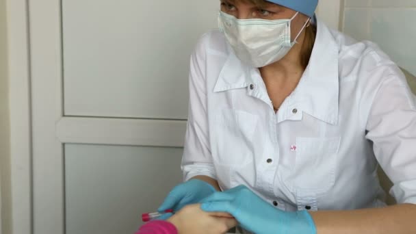 Enfermera toma sangre de un dedo del niño en el laboratorio médico . — Vídeo de stock