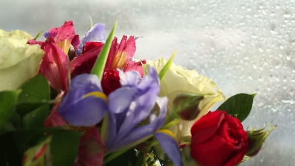 Des gouttes d'eau tombent sur un beau bouquet de roses, d'iris et d'alstroemeria . — Video