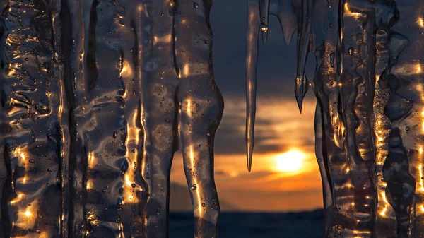 Untergehende Sonne spiegelt sich in Eiszapfen. — Stockfoto