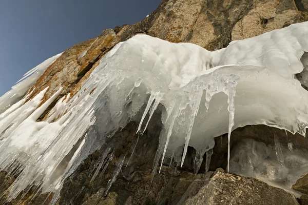 Riesige Eiszapfen auf Felsen. — Stockfoto