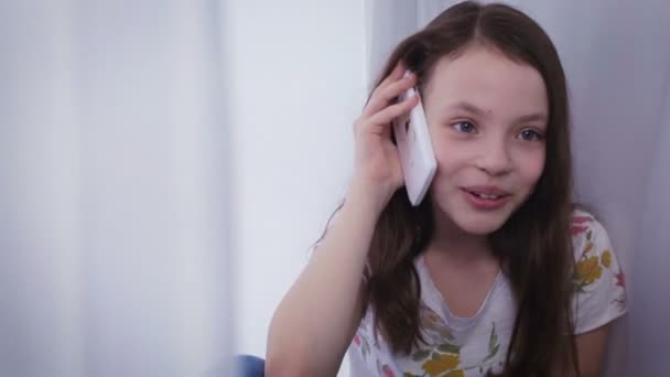 Красива щаслива маленька дівчинка емоційна розмова на смартфоні — стокове відео