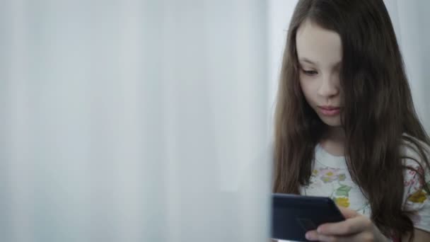 Hermosa niña jugando un juego en la tableta . — Vídeos de Stock