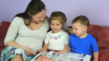 Anne çocuğu olan bir albüm fotoğrafları ile göz önünde bulundurun. Mutlu aile için üçüncü çocuk bekliyor.