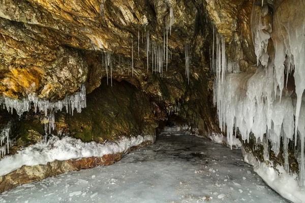 Grotta di pietra multicolore nella scogliera con ghiaccioli . — Foto Stock