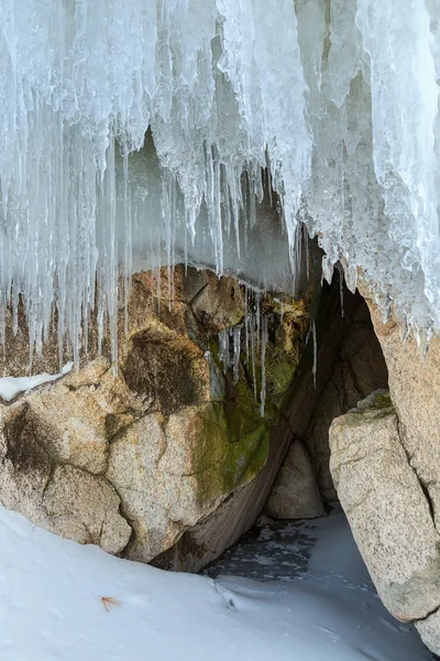 Höhlen und Risse im Fels mit Eiszapfen. — Stockfoto