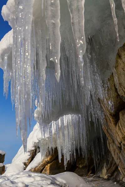 Riesige Eiszapfen auf einer Klippe. — Stockfoto