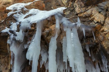 Bir uçurumun üzerinde büyük buz sarkıtları.