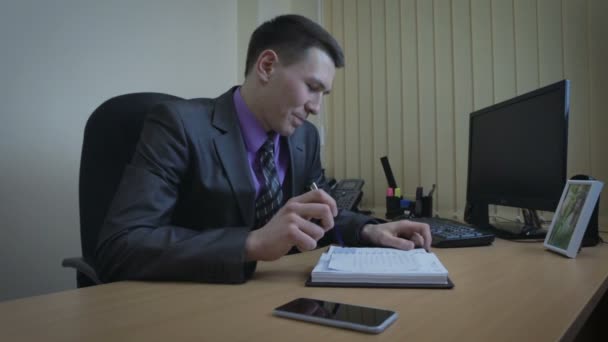 L'homme d'affaires finit son travail. Il regarde la photo et quitte le bureau . — Video