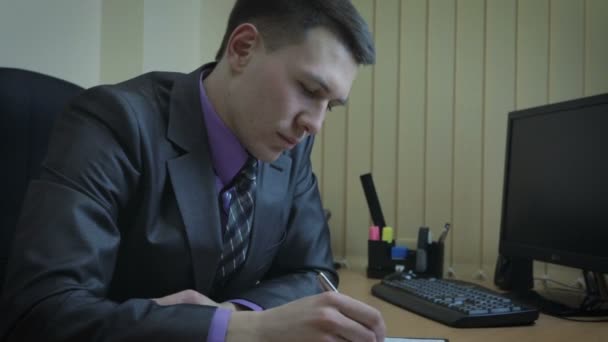 Businessman working in office. He draws attention to the portrait of his beloved. — Stock Video