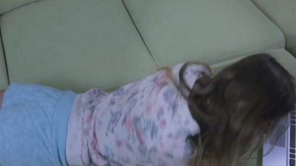 美丽的情感女孩躺在沙发上浅谈智能手机和欢喜. — 图库视频影像