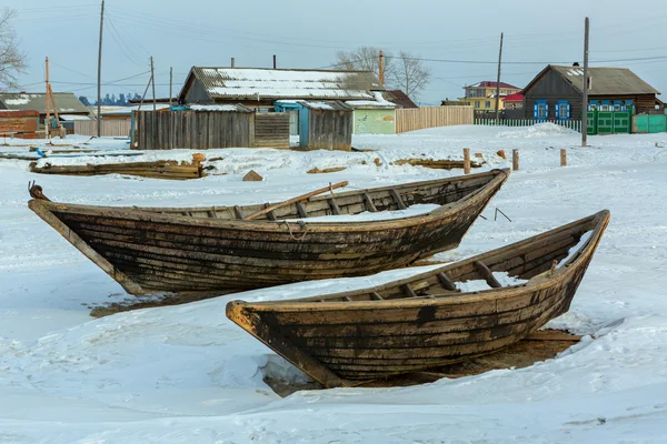 Barca da pesca in legno sulla costa innevata invernale . — Foto Stock