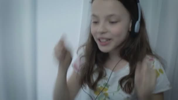 Hermosa niña en auriculares cantando canción emocionalmente y bailando — Vídeos de Stock