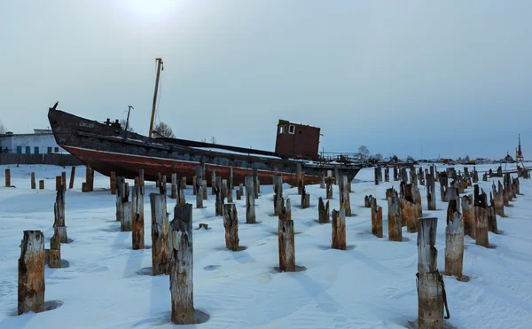 Oud roestig schip aan de winteroever van het Baikalmeer. — Stockfoto