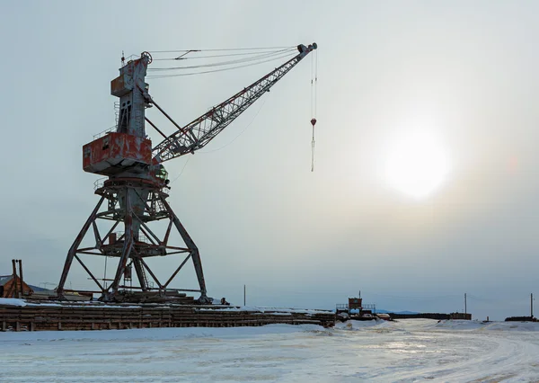 Schepen vracht kranen op de oever van het Baikalmeer in de winter bij zonsondergang. — Stockfoto