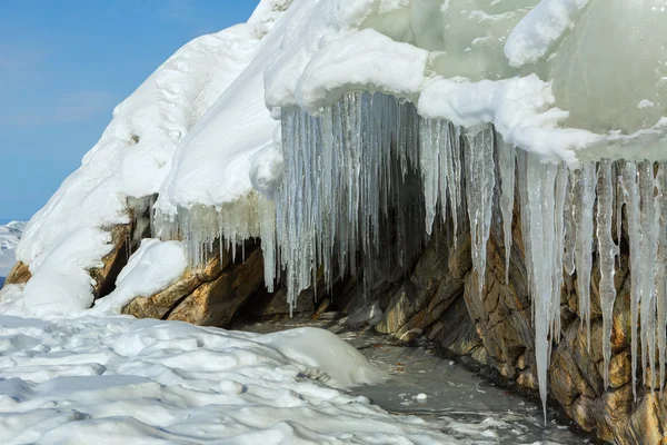 Riesige Eiszapfen auf einer Klippe. — Stockfoto