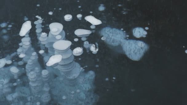 Burbujas y grietas congeladas en el hielo transparente . — Vídeos de Stock