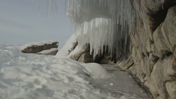 Kayaların üzerinde büyük buz sarkıtları. — Stok video