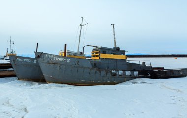 Donmuş gölde kış akşamları karla kaplı gemi