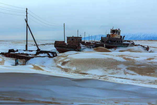 Oud roestig schip aan de winteroever van het Baikalmeer. — Stockfoto