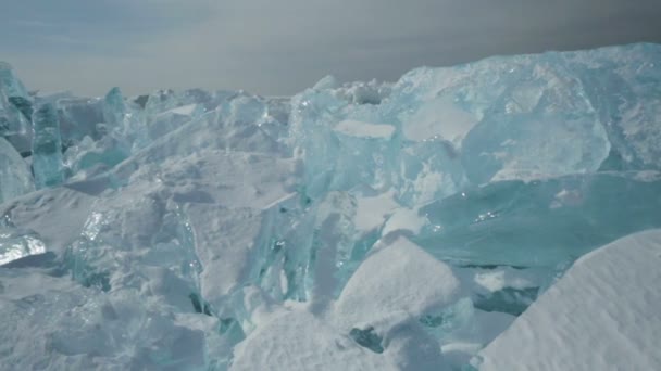 Глыбы синего льда на снегу . — стоковое видео