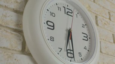 Saat altı saat 30 dakika. Timelapse. Tuğla duvara asılı yuvarlak beyaz saat.