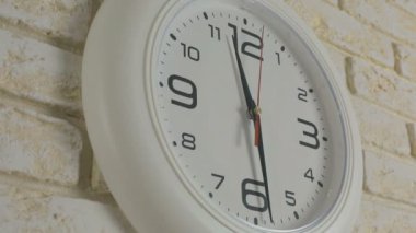Saat on bir saat otuz dakika. Timelapse. Tuğla duvara asılı yuvarlak beyaz saat.